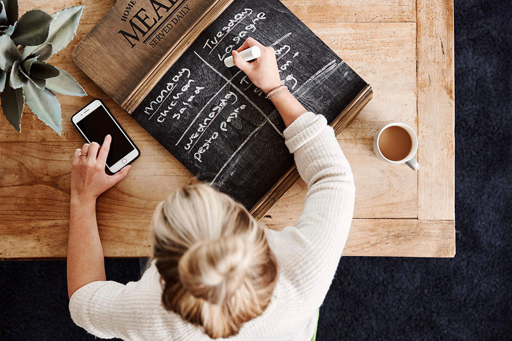 Picture of woman manking menu on chalkboard